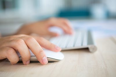 Closeup of business woman hand typing on keyboard and mouse