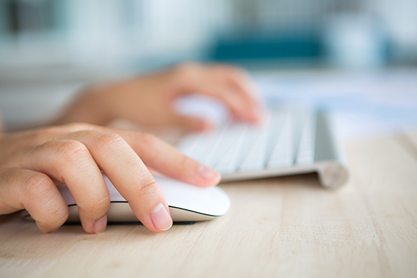 Closeup of business woman hand typing on keyboard and mouse